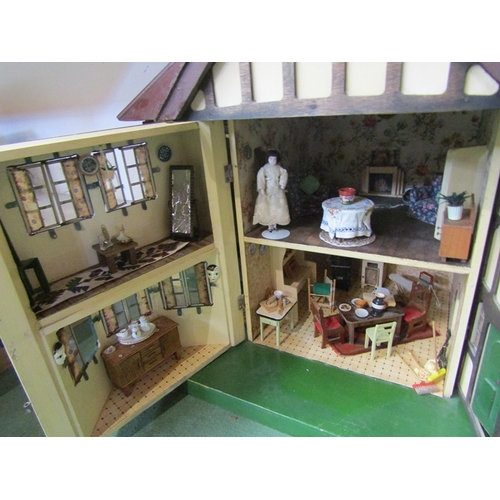 7063 - A large 1930's Tri-ang two storey dolls house with lighting, containing a collection of assorted fur... 