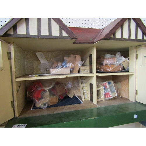 7067 - A Tri-ang two storey dolls house with garage, containing assorted vintage dolls house furniture (67c... 