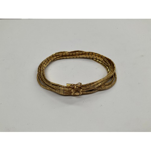 8106 - An 18ct gold seven strand bracelet, 48.7g