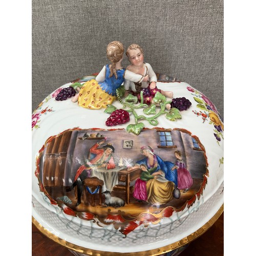 8169 - A modern German porcelain table centrepiece, the lid surmounted by young couple, over hand painted s... 