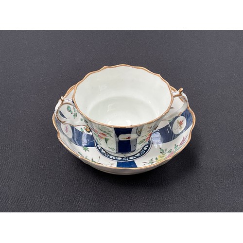 8287 - A Worcester chocolate cup and saucer, blue and white panels depicting floral bouquets, butterflies a... 