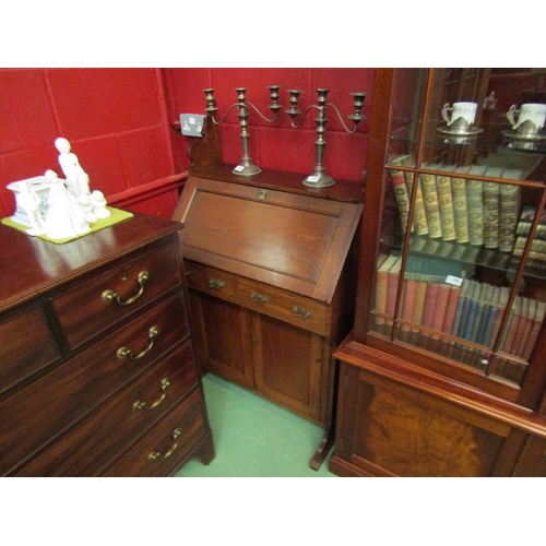 77 - An Arts & Crafts walnut bureau the fall front with key and fitted shelf interior over two drawers an... 