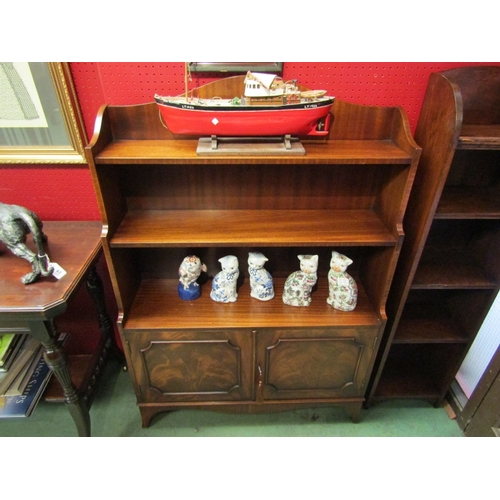 83 - A Bevan Funnell Georgian style flame mahogany waterfall bookshelf over a two door cupboard with work... 