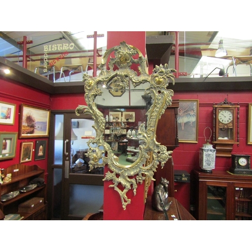 104 - A brass heavily ornate Rococo style wall mirror