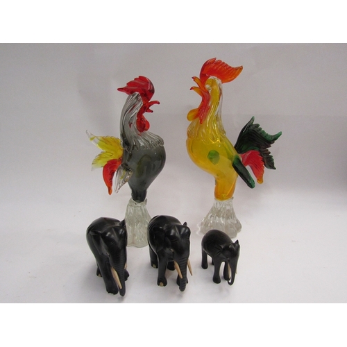 416 - A pair of Murano glass cockerels and three ebony elephants