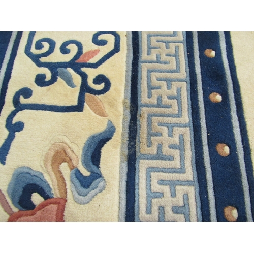 453 - A large hand knotted wool Chinese rug in cream and blue tones, scenes of flora and fauna, tasselled ... 