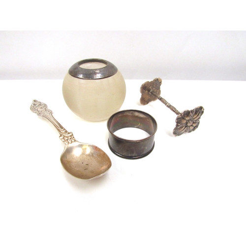 8249 - A silver rimmed match striker, napkin ring and knife rest, together with a decorative spoon (4)