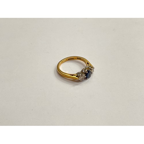 8124 - An 18ct gold sapphire and diamond ring, the central blue sapphire flanked by 0.20ct diamonds. Size K... 