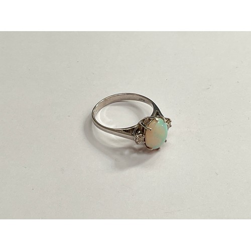 8125 - An 18ct white gold opal and diamond ring. Size K, 2.3g