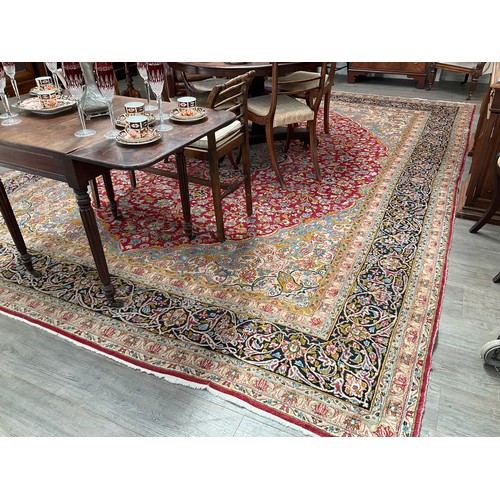 8606 - A Middle Eastern carpet, the central red ground with all over foliage with central gul, within a mul... 