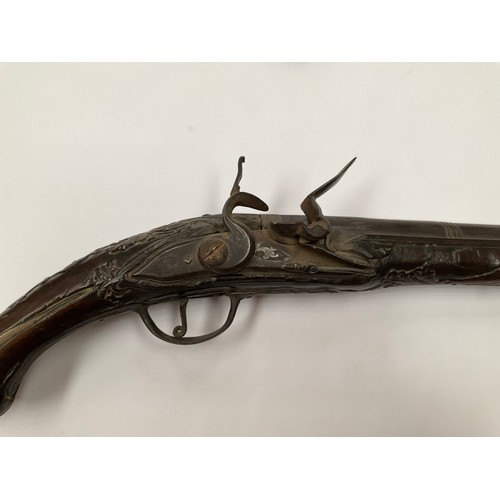 5326 - A late 18th Century flintlock pistol with all over scrolled foliate carving, part of mechanism missi... 