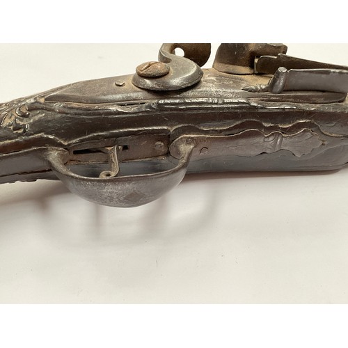 5326 - A late 18th Century flintlock pistol with all over scrolled foliate carving, part of mechanism missi... 