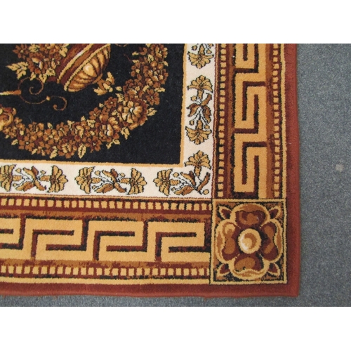 1474 - A large wool rug, black ground with gold and brown floral decoration and a Greek key border, 236cm x... 