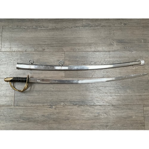 5429 - A replica cavalry sabre with brass three bar hilt, black leather and wired grip, steel scabbard