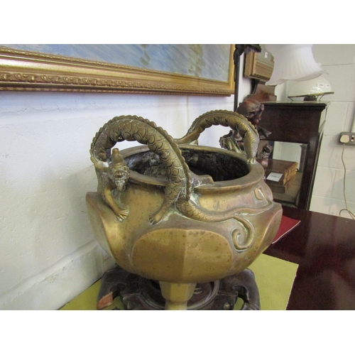 1015 - A 20th Century Oriental heavy metal censer with dragon handles on carved wooden base, a/f