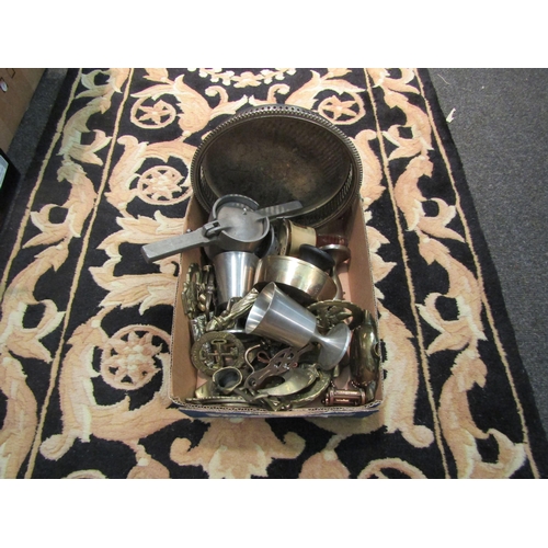 1051 - A tin of horse brasses, a box of metal wares and a brass magazine rack