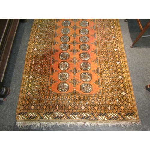 1109 - A 20th Century orange ground geometric design Eastern wool rug, tasselled ends, faded, 198cm x 114cm