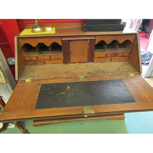 156 - A country house oak bureau with mahogany crossbanding the fitted interior and fall with key over two... 