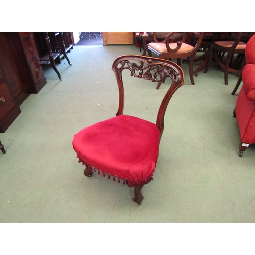 184 - A 19th Century mahogany nursing chair with heavily carved back rail, red velour upholstery scroll fr... 