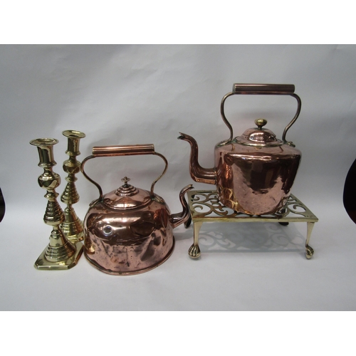 393 - Two copper teapots, a pair of brass candlesticks and a pierced brass trivet