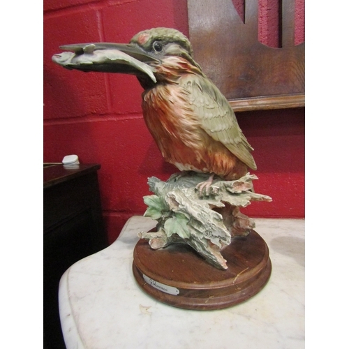 144 - A resin figure of a kingfisher with catch, signed on a wooden plinth, 33cm high