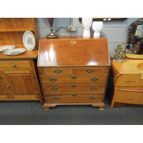 1040 - A mahogany reproduction bureau in the 18th Century style. Two short over three graduating long drawe... 