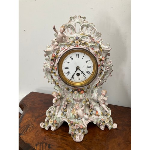 1336 - A late 19th Century highly ornate ceramic mantel clock decorated in the Rococo style with putti and ... 