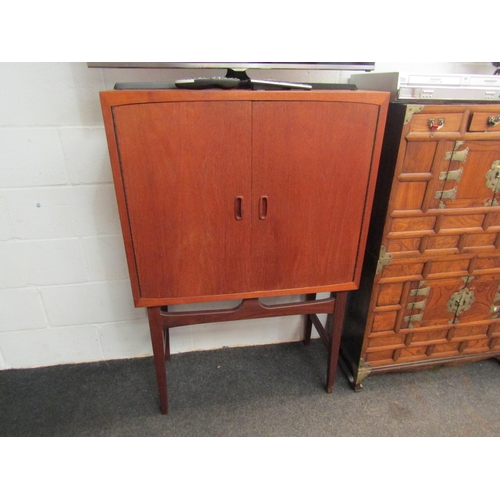 1031 - A retro 1970s teak drinks cabinet with shelved mirrored interior. 127cm x 83cm x 40cm