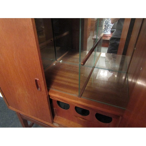 1031 - A retro 1970s teak drinks cabinet with shelved mirrored interior. 127cm x 83cm x 40cm