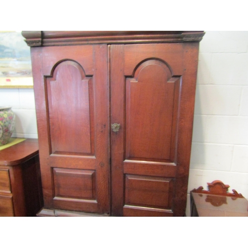 1057 - An early to mid 18th Century oak slim two door cupboard over two over two drawer base with swan neck... 