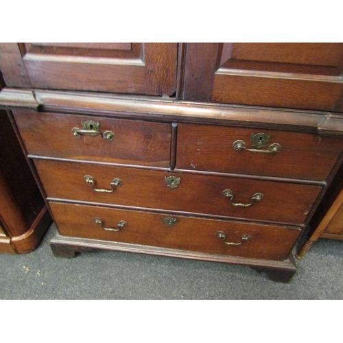 1057 - An early to mid 18th Century oak slim two door cupboard over two over two drawer base with swan neck... 