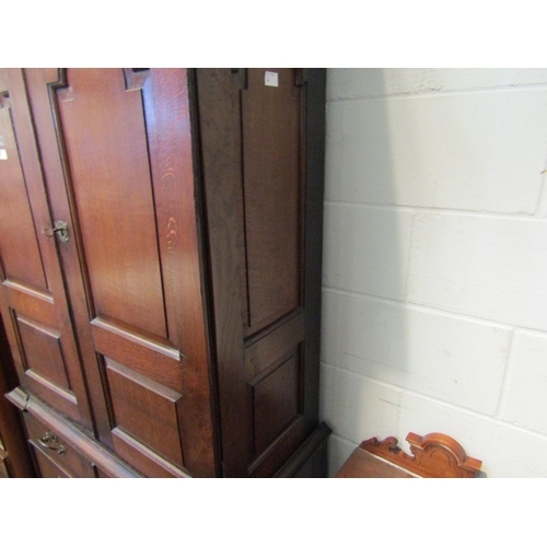 1057 - An early to mid 18th Century oak slim two door cupboard over two over two drawer base with swan neck... 