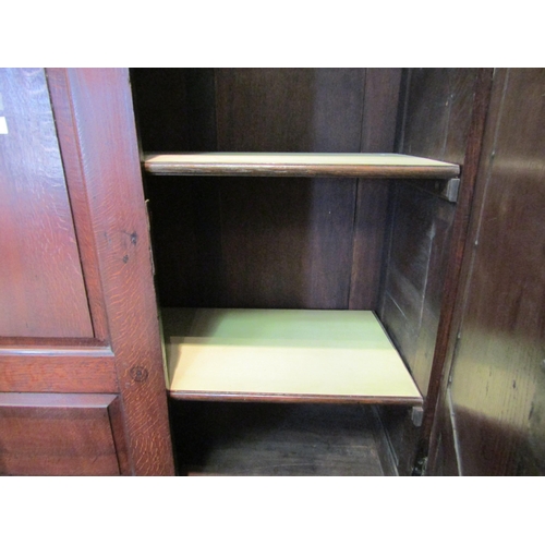 1057 - An early to mid 18th Century oak slim two door cupboard over two over two drawer base with swan neck... 