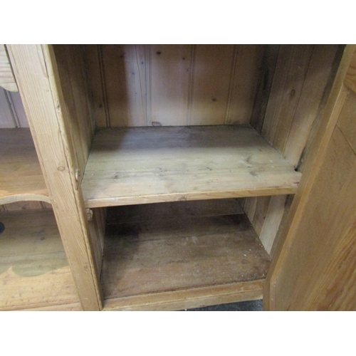 1073 - A 19th/20th Century pine dresser base. Three drawers over two cupboard doors flanking a shelved rece... 