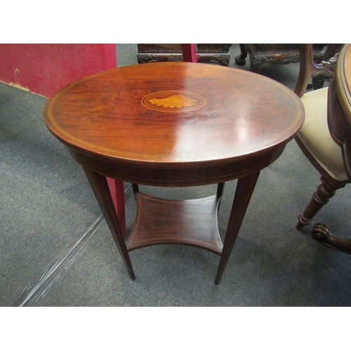 1108 - A Edwardian mahogany two tier oval occasional table, inlaid with a shell patera