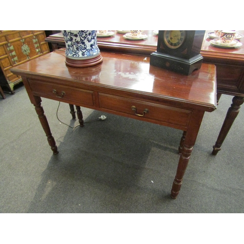 1125 - An Edwardian mahogany two drawer side table with turned legs, line detail. 72cm x 196cm x 48cm