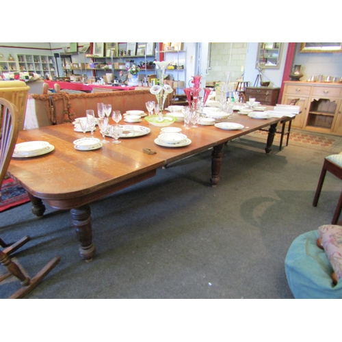 1139 - A late 19th/early 20th Century oak extending dining table with four extra leaves. Approx. 12ft long