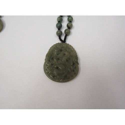 1269 - A carved jade dragon pendant, two bracelets and a necklace