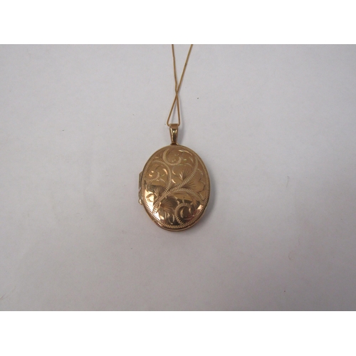 1278 - A 9ct gold oval engraved locket hung on 9ct gold chain 5.9g