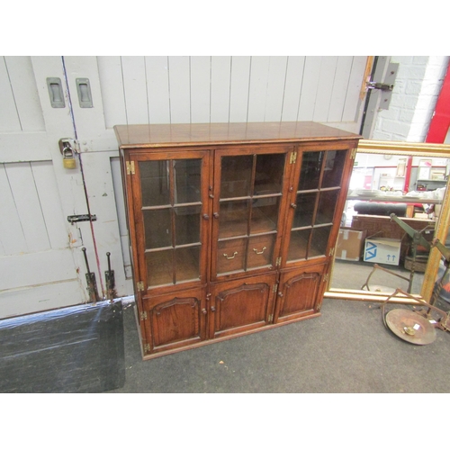 1190 - A reproduction oak display cabinet, cupboards over three further cupboards with plug in lights to ba... 