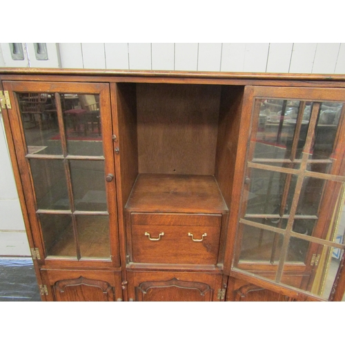 1190 - A reproduction oak display cabinet, cupboards over three further cupboards with plug in lights to ba... 