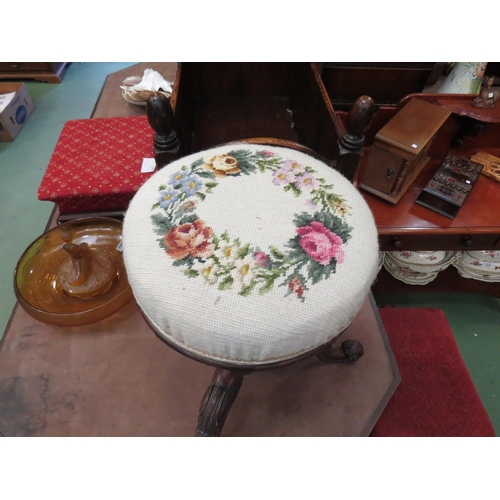 4010 - A Victorian mahogany revolving piano stool with carved cabriole legs, needlepoint tapestry seat