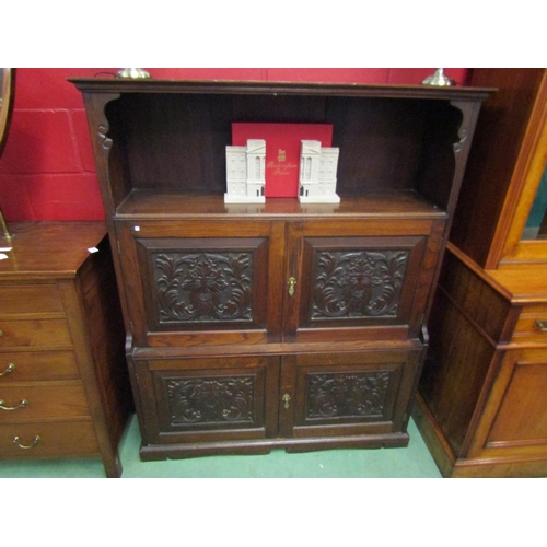 4128 - An oak hall cupboard with carved Green Man panels.  Shelved interior to cupboard doors.  121cm wide ... 