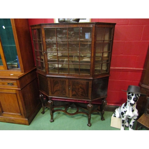 4134 - A circa 1800 revival walnut canted corver vitrine the panel glazed single door over a two door cupbo... 