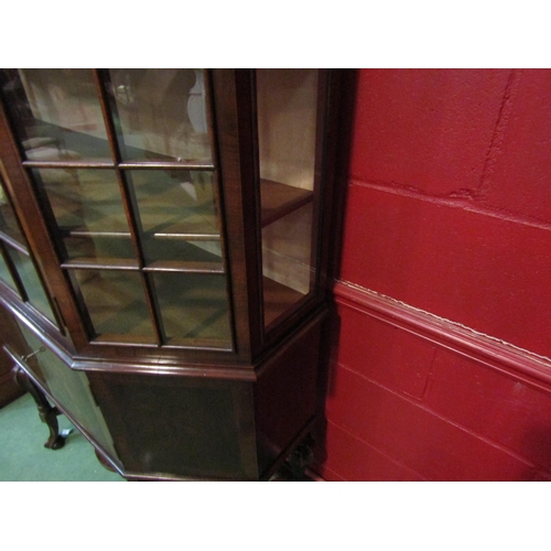 4134 - A circa 1800 revival walnut canted corver vitrine the panel glazed single door over a two door cupbo... 