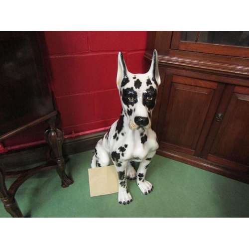 4136 - A large porcelain figure of a seated harlequin great dane made in Italy, with an original receipt, 8... 