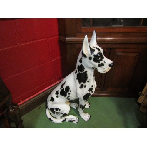 4136 - A large porcelain figure of a seated harlequin great dane made in Italy, with an original receipt, 8... 