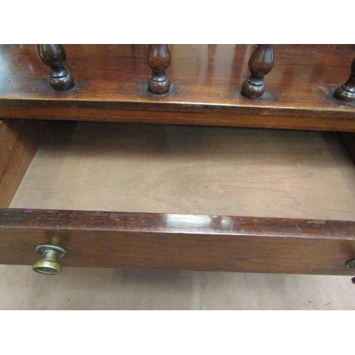 4207 - A mahogany Canterbury on castors with turned supports and drawers, 53cm tall