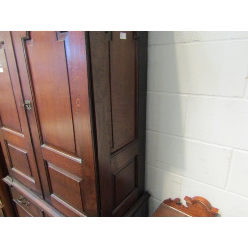 1053 - An early to mid 18th Century oak slim two door cupboard over two over two drawer base with swan neck... 