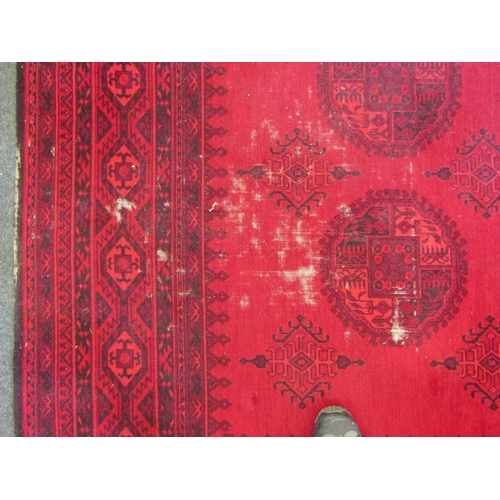 1542 - An Afghan wool carpet, three rows of central guls, multiple borders, 366cm x 275cm